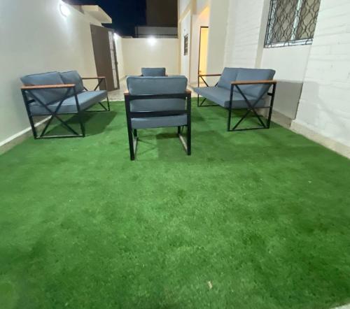 a group of chairs sitting on a green floor at الرس in Al Rass