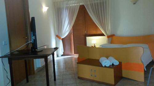 a bedroom with a bed with a desk and a television at Hotel Il Baronetto in Tarsia