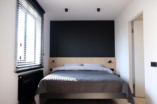 una camera da letto con un letto con una parete nera di Rose Valley Apartment a Chişinău