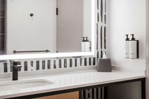 a bathroom with a sink and a mirror at Atwell Suites Austin Airport by IHG in Austin