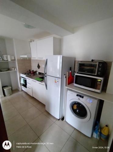 a kitchen with a refrigerator and a washing machine at Mirando al Sol Ushuaia in Ushuaia