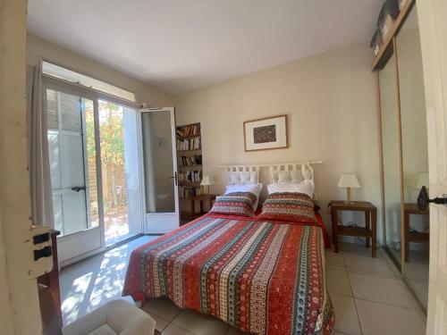 - une chambre avec un lit et une couverture colorée dans l'établissement LA CIOTAT 3 chambres plage et jardin, à La Ciotat