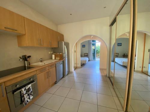 - une cuisine avec des placards en bois et une arche dans l'établissement LA CIOTAT 3 chambres plage et jardin, à La Ciotat