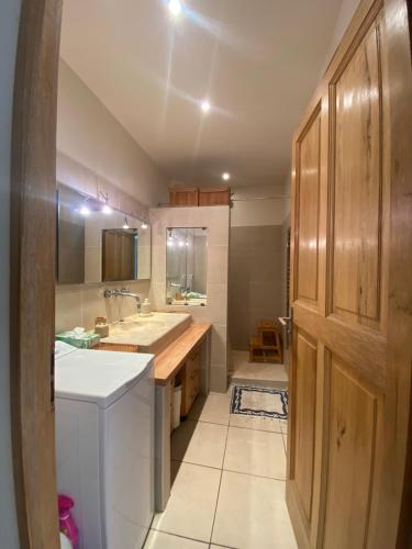 une grande cuisine avec un évier et une porte en bois dans l'établissement LA CIOTAT 3 chambres plage et jardin, à La Ciotat