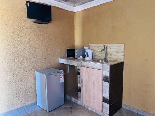 una cucina con bancone, lavandino e frigorifero di The journey guest house a Mzinti