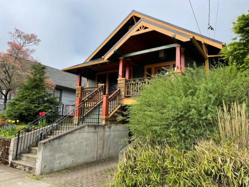 une maison avec une terrasse couverte et des escaliers menant à celle-ci. dans l'établissement Alberta Arts Craftsman ADU, à Portland