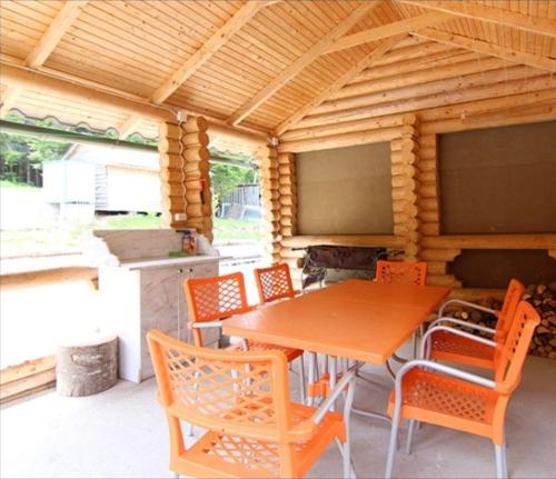 een houten tafel en stoelen op een patio met een keuken bij Карпатський затишок in Oryavchyk