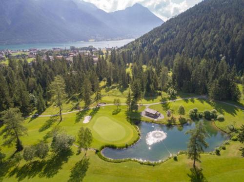 an aerial view of a golf course with a lake at TIROLER TRIS modern villa 10 beds in Maurach