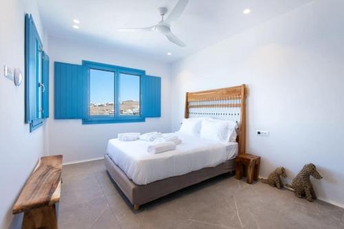 Heaven Villa by Bestofmikonos في أورنوس: غرفة نوم بسرير كبير ونافذتين