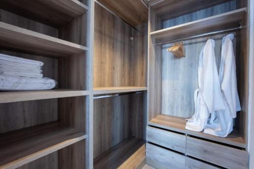 Heaven Villa by Bestofmikonos في أورنوس: خزانة ملابس مع رفوف ومناشف خشبية