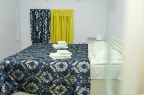 a bedroom with a bed with towels on it at Restland Dilijan Family Hotel in Dilijan
