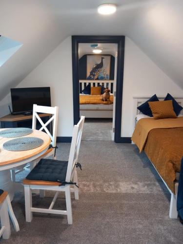 1 dormitorio con cama, mesa, cama y espejo en The Irish Highlands Haven en Ennis