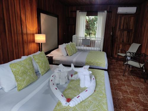 a bedroom with two beds with a heart made out of towels at Casona Rústica & Bungalow in Fortuna