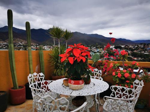 a table and chairs with flowers on a balcony at Casa Donaji in Oaxaca City