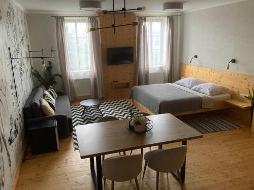 1 dormitorio con cama, mesa y sofá en Apartmány Štěpánkova 85, en Chrudim