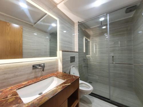 a bathroom with a sink and a toilet and a shower at The Moziac Hotel in Gwalior