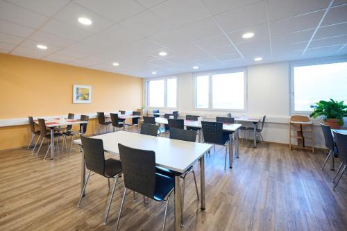 a large room with tables and chairs and windows at Smart Hotel Kreisel --Self check-In in Lachen