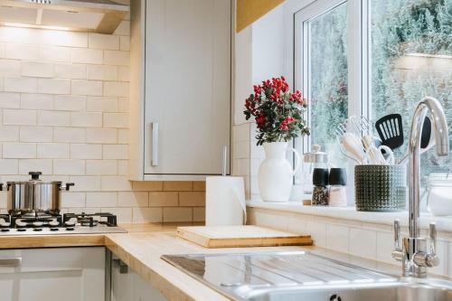 une cuisine avec évier et cuisinière ainsi qu'une fenêtre dans l'établissement 3 Bed - Modern Comfortable Stay - St Helens Town Centre, à St Helens