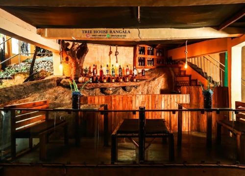 a bar with a counter with bottles of alcohol at Tree House Rangala in Hunnasgiriya