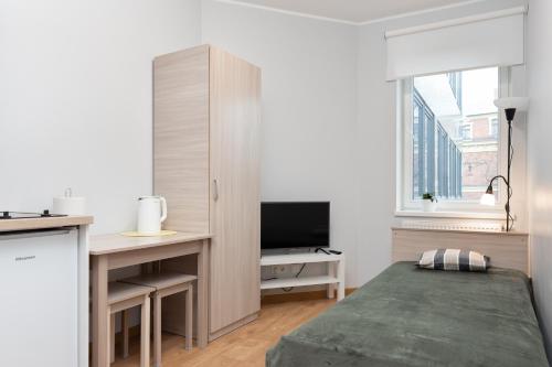 een slaapkamer met een bed en een bureau met een televisie bij Pepleri Studio 29 in Tartu
