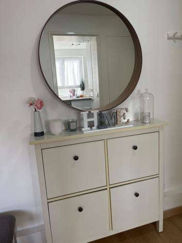 - une commode avec un miroir au-dessus dans l'établissement O'Rits Paris - Magnifique appartement proche Paris, à Rueil-Malmaison