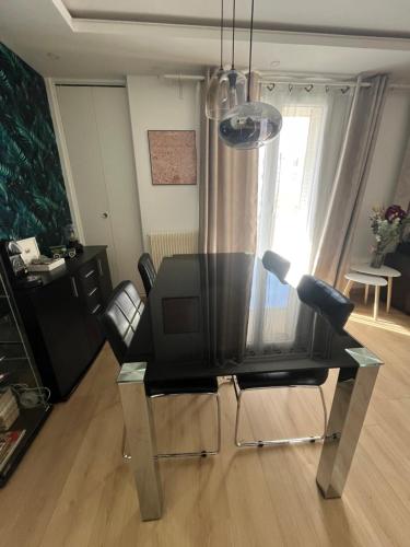 a dining room table with chairs and a television at O'Rits Paris - Magnifique appartement proche Paris in Rueil-Malmaison