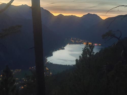a view of a city and a lake at sunset at TIROLER TRIS modern villa 10 beds in Maurach