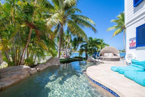 a swimming pool with palm trees and a resort at Flip Flop Kai home in North Side