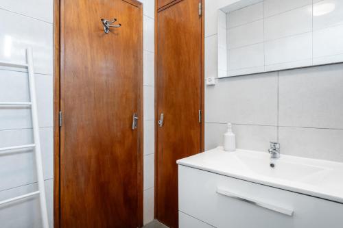 baño con armario de madera junto a un lavabo en Vivenda MiraSerra, en Santana