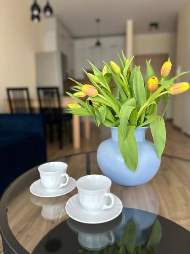 a blue vase with a bouquet of flowers on a table at Apartament Jasna Góra in Częstochowa