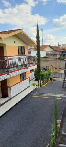 a house with a fence next to a driveway at Flat MP Pluma in Araxá