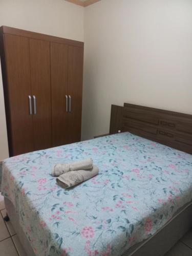 een slaapkamer met een bed met twee handdoeken erop bij Flat MP Pluma in Araxá