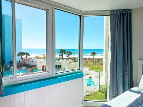 a bedroom with windows with a view of the beach at Beachfront Studio - Perfect Location - Free Beach Chairs in Panama City Beach