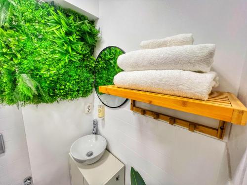 baño con plantas verdes y toallas en un estante en São Domingos Residences I, en Oporto