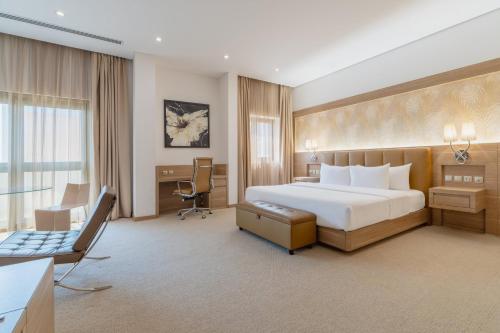 um quarto de hotel com uma cama e uma secretária em Carlton Al Moaibed Hotel em Dammam