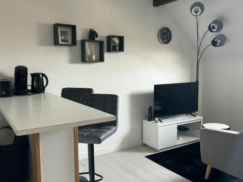 a living room with a desk and a television at New Studio Cosy - Proche RER et centre ville in Brétigny-sur-Orge