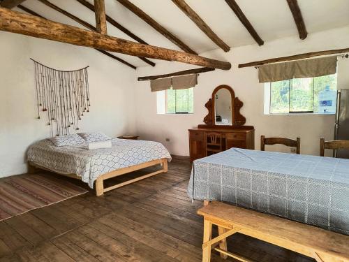 a bedroom with two beds and a table and windows at Casona Don Giovanni in Lamay