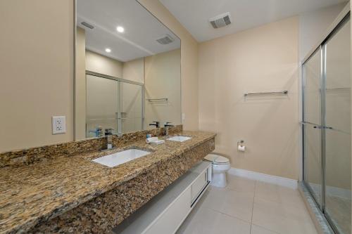 a bathroom with two sinks and a large mirror at 4 BR Home w/ Resort Amenities + 3 Mi to Disney in Orlando
