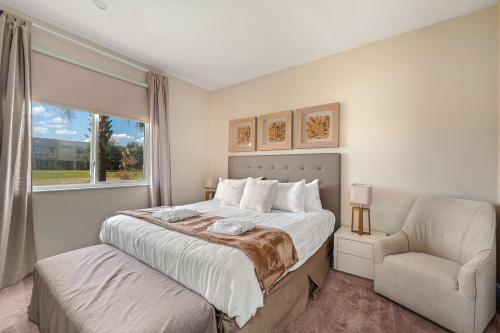 a bedroom with a bed and a chair and a window at 4 BR Home w/ Resort Amenities + 3 Mi to Disney in Orlando