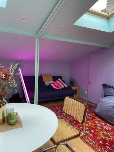 une pièce avec des murs violets et une table et des chaises dans l'établissement Ancien atelier artiste, studio climatisé, à Bordeaux