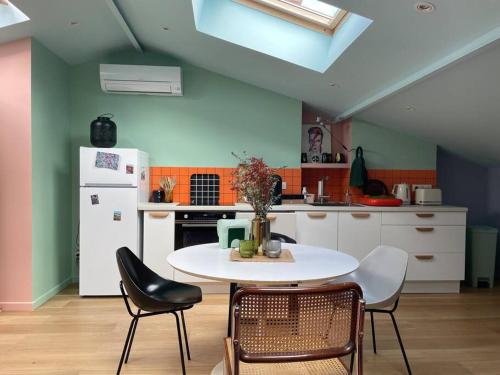 une cuisine avec une table, des chaises et un réfrigérateur dans l'établissement Ancien atelier artiste, studio climatisé, à Bordeaux