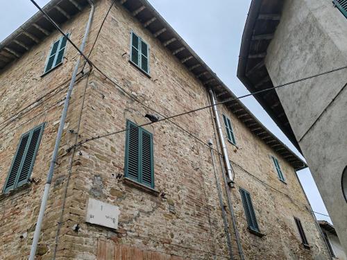 Dimora Storica في Petrignano: مبنى من الطوب عليه مصاريع خضراء