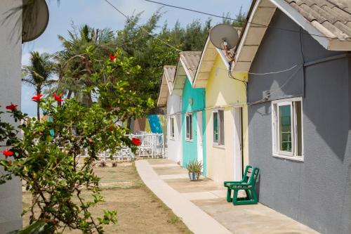 a row of houses with a green bench next to it at Tahiti Hotel in Cotonou