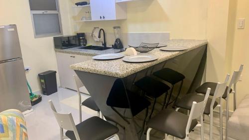 a kitchen with a island with chairs and a counter top at Hermosa suite 3 elegante con jacuzzi in Guayaquil