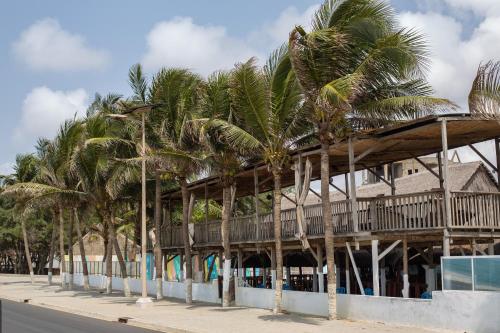 a row of palm trees in front of a building at Tahiti Hotel in Cotonou