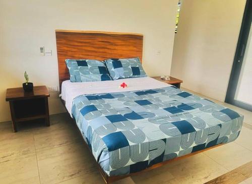 uma cama com um edredão azul e branco num quarto em Harmonious Bella Villa em Pacific Harbour