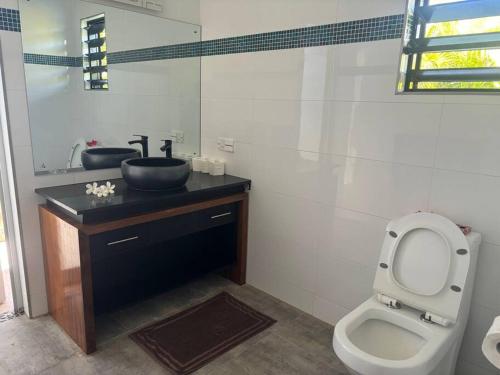 uma casa de banho com um lavatório e um WC em Harmonious Bella Villa em Pacific Harbour