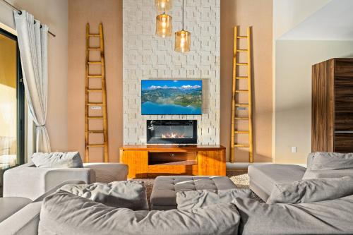 a living room with a couch and a fireplace at Outdoor Kitchen + 8 Min to Disney + Resort Cabanas in Orlando