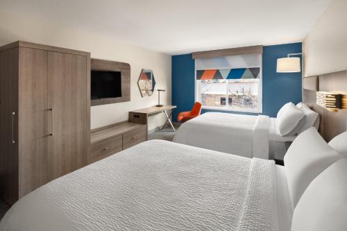 a hotel room with two beds and a flat screen tv at Holiday Inn Express Hotel & Suites Cherry Hills by IHG in Omaha