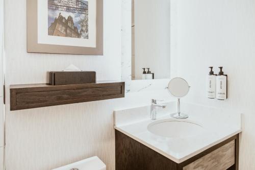 a bathroom with a sink and a mirror at Crowne Plaza Fredericton Lord Beaverbrook by IHG in Fredericton